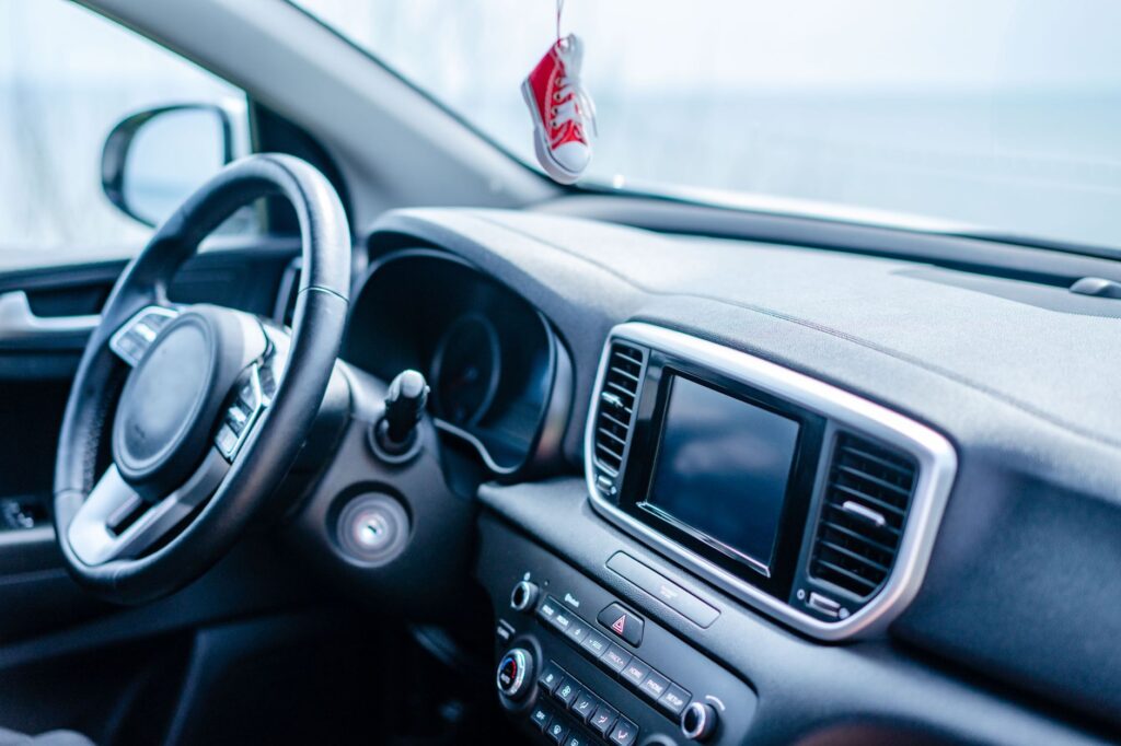 Close-up view of a modern car interior focusing on the steering wheel and dashboard.