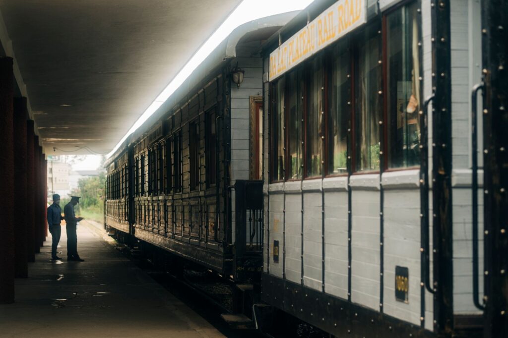 Historic train awaiting departure at Da Lat railway station platform, Vietnam.