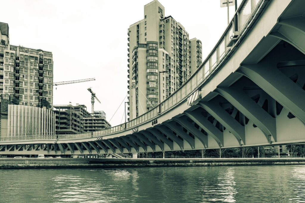 An architectural view of a bridge and skyscrapers in a cityscape setting under daylight.