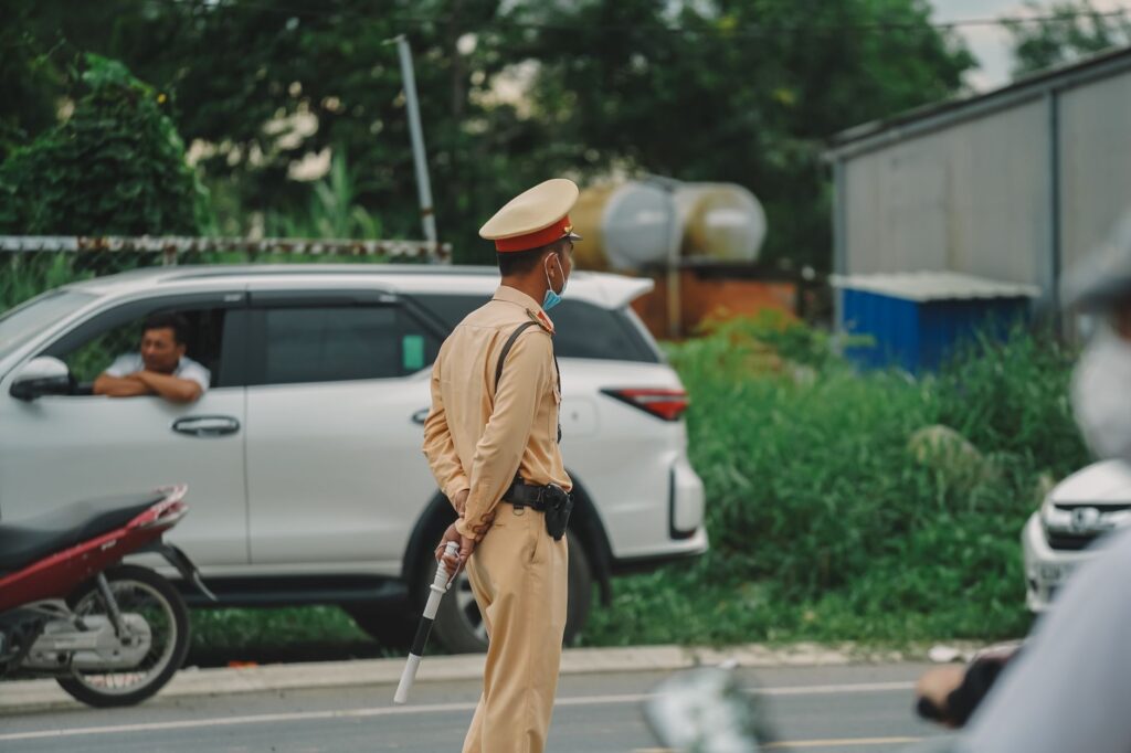 Traffic officer managing road with vehicles in an urban outdoor setting.