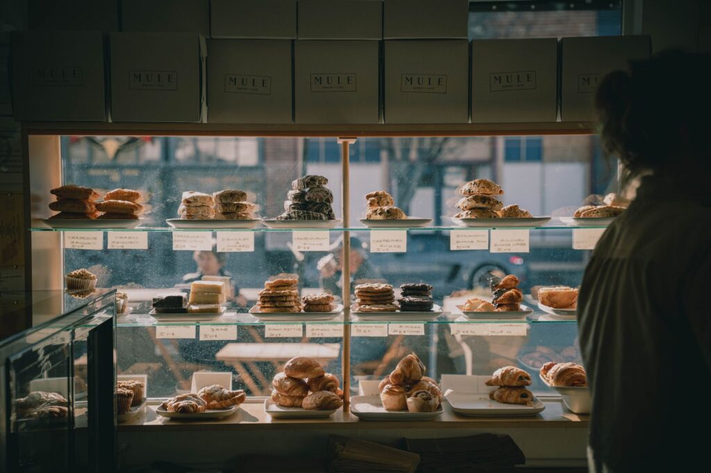 Warm bakery setting showcasing assorted pastries on display shelves.
