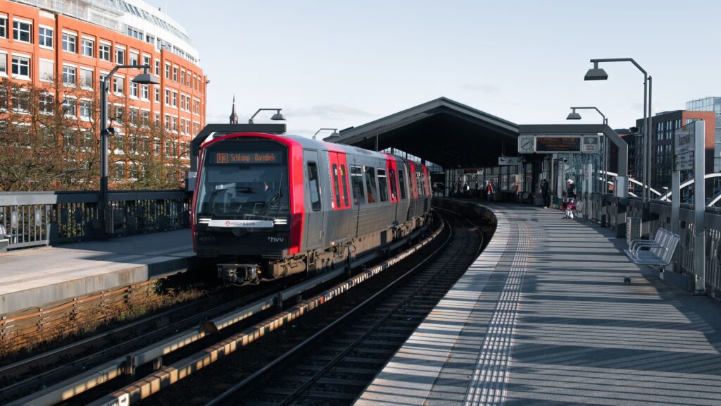 A commuter train arrives at a modern outdoor station in Hamburg, Germany.