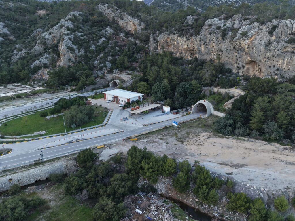 An aerial view showcasing the tunnel entrance surrounded by rugged hills and greenery in Antalya, Türkiye.