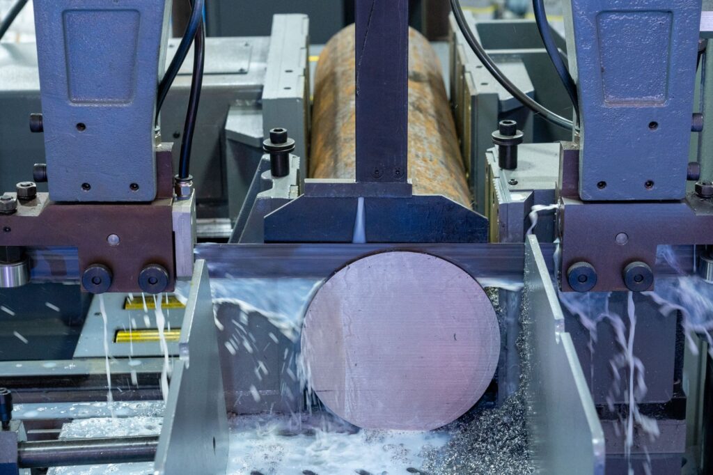 Close-up of an industrial machine cutting a metal rod with precision.