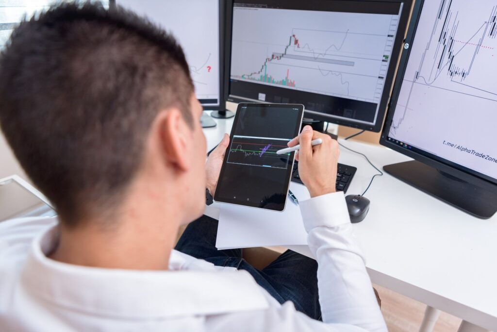 A trader reviewing cryptocurrency charts on a tablet in a modern office setting.