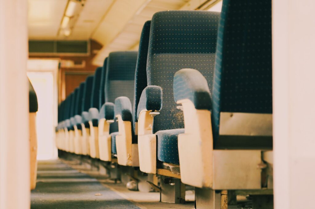 A close-up view of empty blue seats in a subway train interior.