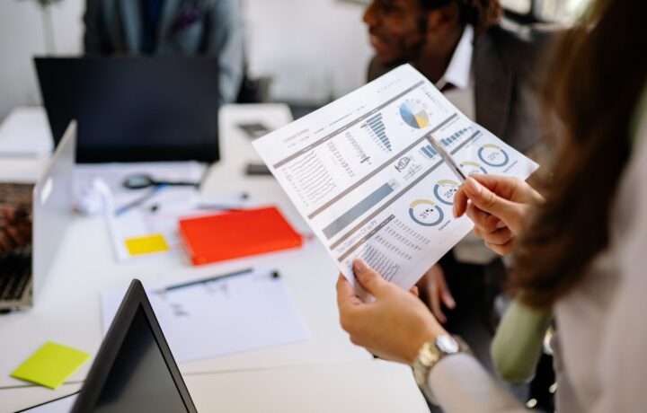 Professionals reviewing business charts and documents in a team meeting.