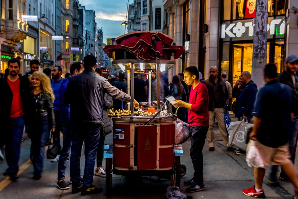 A vibrant street food vendor serving customers in a busy urban setting, capturing the night ambiance.