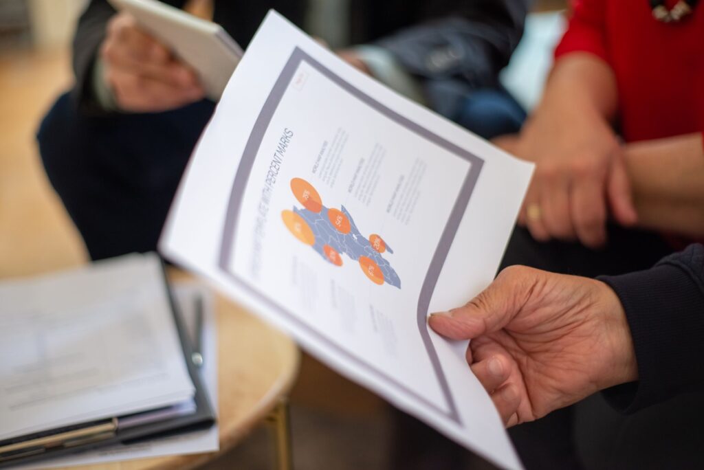 Close-up of professionals reviewing business documents in a meeting setting.