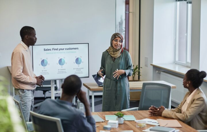 A diverse group of professionals in a business meeting discussing sales strategies.