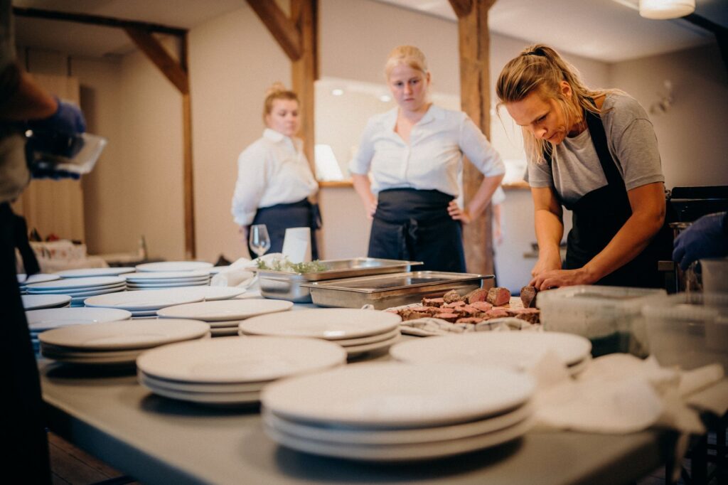 Chefs working together in a restaurant kitchen, preparing gourmet dishes for upcoming service.